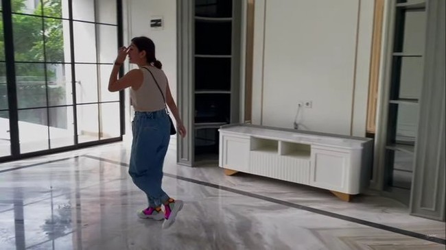 Rumah baru Syahnaz hadir dalam desain klasik-modern yang stylish. Rasa tersebut hadir lewat material-material seperti lantai marmer putih di ruangan ini yang nantinya akan ditempatkan TV dan piano. (Foto: YouTube/NizNaz Channel)