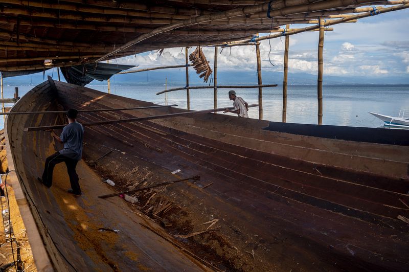 Sejumlah pekerja merampungkan pembuatan kapal ikan di Galangan Kapal Rakyat (GKR) Donggala, Sulawesi Tengah, Senin (24/5/2021). Para pelaku industri kapal rakyat di wilayah itu mengaku kerap mengalami keterlambatan penyelesaian pembuatan kapal ikan karena sulitnya mendapatkan kayu Ulin sebagai bahan baku pembuatan kapal. ANTARAFOTO/Basri Marzuki/foc.