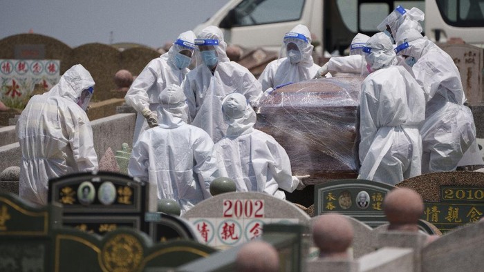 Health workers wearing Personal Protective Equipment (PPE) carry a coffin during a funeral for a COVID-19 victim in Klang, Malaysia, Sunday, May 23, 2021. Malaysia unexpectedly imposed a one-month lockdown through June 7, spooked by a sharp rise in cases, more-infectious variants and weak public compliance with health measures. (AP Photo/Vincent Thian)