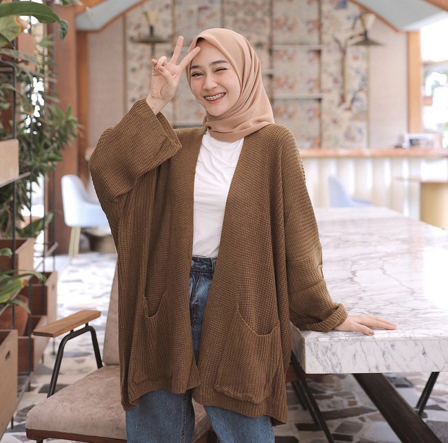 Buat kamu hijabers yang tak mau ribet, cardigan rajut bisa membuat penampilan kamu semakin stylish. Seperti selebgram hijab Sinta Sri Antan ini, ia mengenakan oversized outer knit cokelat tua dengan kaus putih dan jeans. Foto: Dok. Instagram @sin.sr.