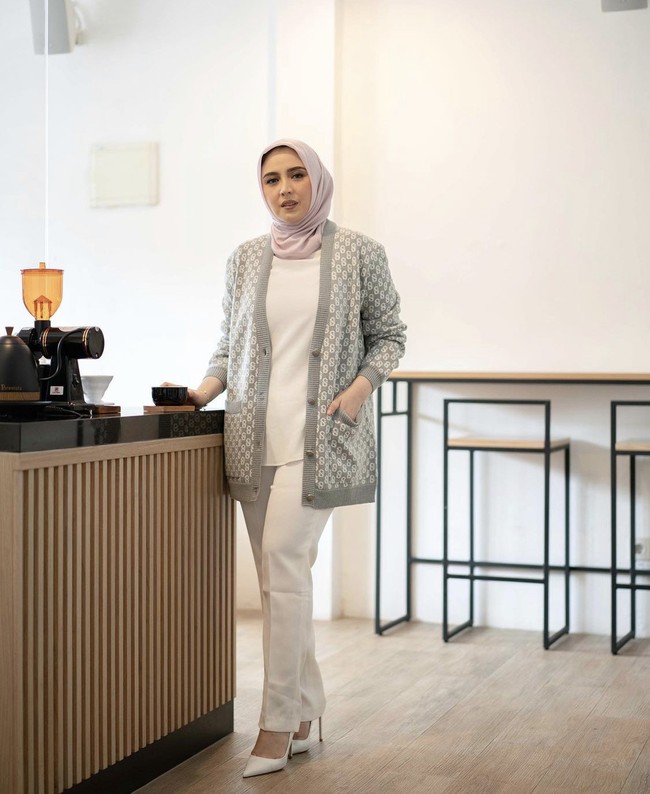 Bahan knit atau rajut bisa kamu padu padankan dengan berbagai item fashion. Seperti yang dipakai oleh influencer hijab Sarah Sofyan. Ia memakai outer knit abu-abu panjang, dipadu dengan atasan, pants dan high heels putih. Foto: Dok. Instagram @sarsof.