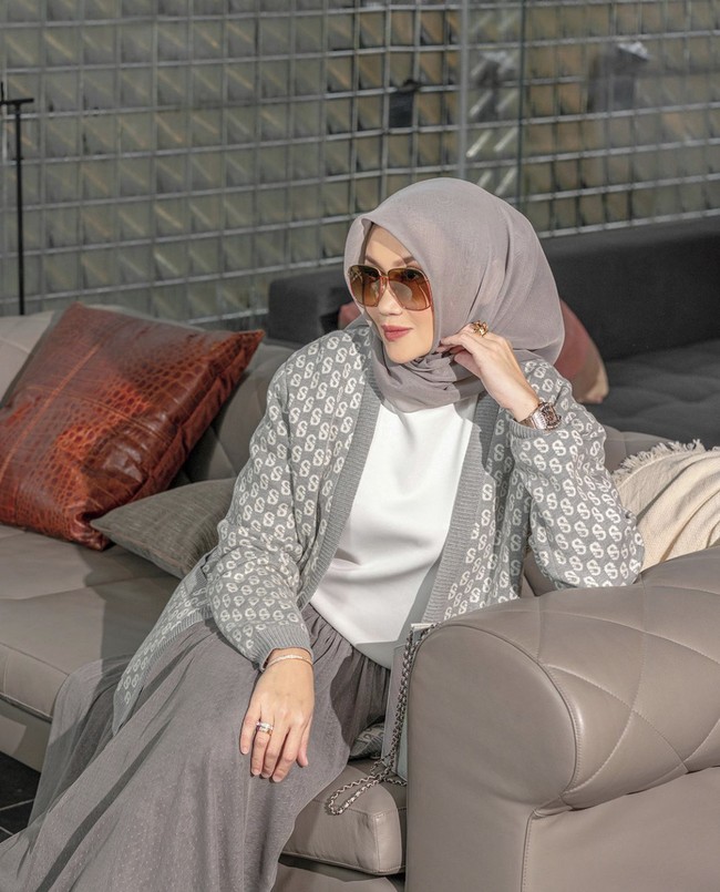 Gaya padu padan cardigan rajut selanjutnya ada dari Diana Dsaks. Selebgram hijab dan sosialita ini mengenakan hijab segi empat, outer rajut dan rok bernuansa abu-abu. Ia memadukan atasan warna putih agar terlihat semakin stylish. Foto: Dok. Instagram @buttonscarves.