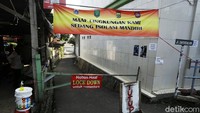 Warga menutup gang dengan besi yang dipasang melintang. Mereka juga memasang spanduk kecil bertuliskan Mohon Maaf Lockdown Untuk Sementara.