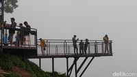 Di Awang-awang, wisatawan bisa berfoto maupun selfie dengan latar belakang pemandangan alam maupun gunung persis di atas kaca. Kaca yang diinjak pengunjung ini aman bagi wisatawan sekalian uji adrenalin. (Eko Susanto/detikTravel)