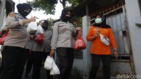 Sejumlah polwan ikut membantu warga membagikan logistik berupa makanan untuk warga.