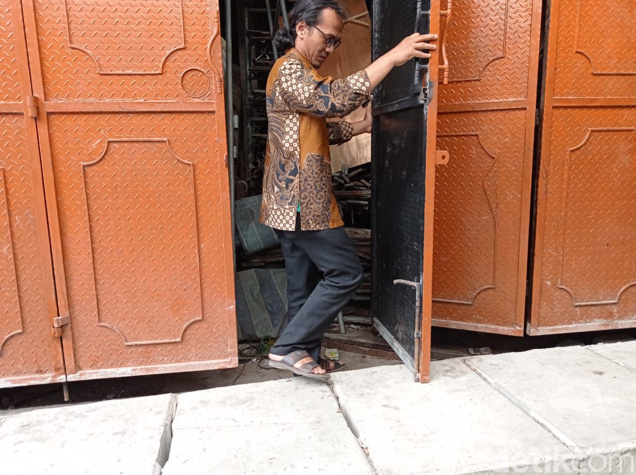 Agung Rahadian menunjukkan daun pintunya yang masih mentok dengan penutup got. 27 Mei 2021. (Sachril Agustin Berutu/detikcom)