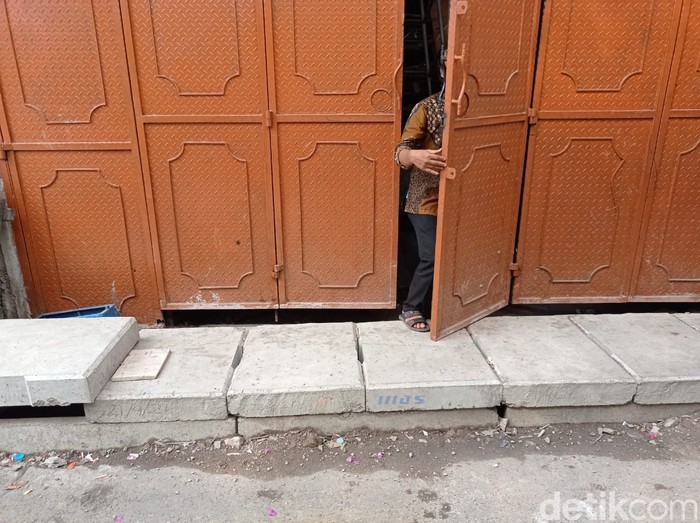 Agung Rahadian menunjukkan daun pintunya yang masih mentok dengan penutup got. 27 Mei 2021. (Sachril Agustin Berutu/detikcom)