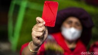 Bak wasit sepakbola, emak-emak ini mengacungkan kartu merah ke arah gedung Kementerian Lingkungan Hidup dan Kehutanan (KLHK).