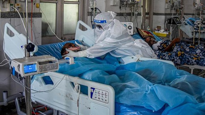 MUMBAI, INDIA - MAY 27: A patient who has Covid-19 sits on his bed in an ICU ward at the government-run St. George hospital on May 27, 2021 in Mumbai, India. India's prolonged and devastating wave of Covid-19 infections has gripped cities and overwhelmed health resources. (Photo by Fariha Farooqui/Getty Images)