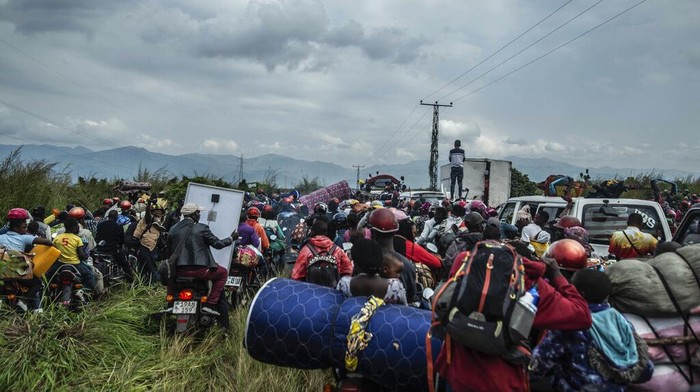 People who fled Goma, Congo, gather at a food distribution point Friday, May 28, 2021 in Sake, some 25 kms (16 miles) west of Goma where they found shelter following an official evacuation order five days after Mount Nyiragongo erupted. (AP Photo/Moses Sawasawa)