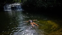 Warga suku mandi ritual di air terjun Iriri untuk berterima kasih kepada Deus Tupã di Paraty, Brasil.  