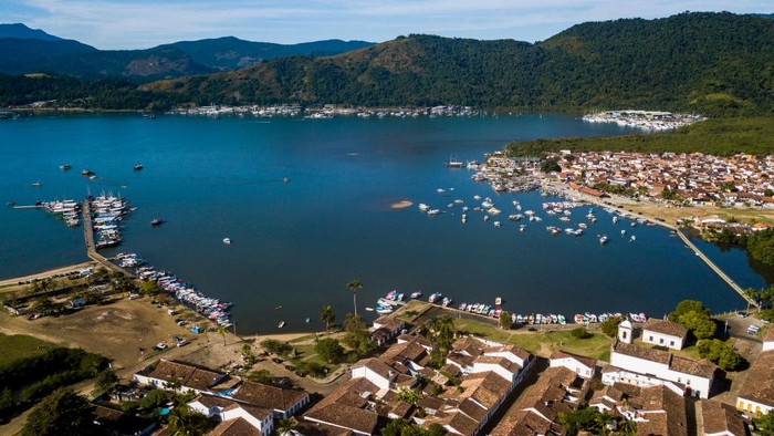 PARATY, BRAZIL - MAY 24: Hauny Pataxó wraps fish with patioba leaves before grilling them on May 24, 2021 in Paraty, Brazil. The Pataxó Hã Hã Hãe live in a village 30km away from the historic center of Paraty, in the coastline of the state of Rio De Janeiro. The community has 62 members from 15 families. Before the coronavirus pandemic, they made a offering tours around their village and selling handicrafts to tourists. Since the outbreak of COVID, their income sources have been affected as the number of visitors plummeted from 200 to zero per day. They have launched an on-line campaign to raise donations while they await for more help from the government. Three cases of COVID were registered among the villagers, who stick to their ancestral medicine to treat and prevent diseases. (Photo by Buda Mendes/Getty Images)