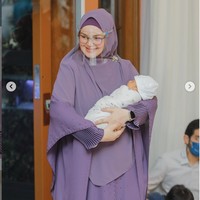 Saat acara akikah anaknya, pelantun Cindai itu tampil dengan busana muslim ungu rancangan Shanel Harun. Siti tampak mengenakan face shield sebagai upaya mematuhi protokol kesehatan pencegahan COVID-19. Foto: Dok. Instagram@ ctdk