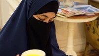 Nah, ini salah satunya momen cantik Umi Pipik kala menikmati minuman dari saffron. Sambil memegangi cangkir, Umi Pipik juga sambil membaca majalah. Foto: Instagram @_ummi_pipik_