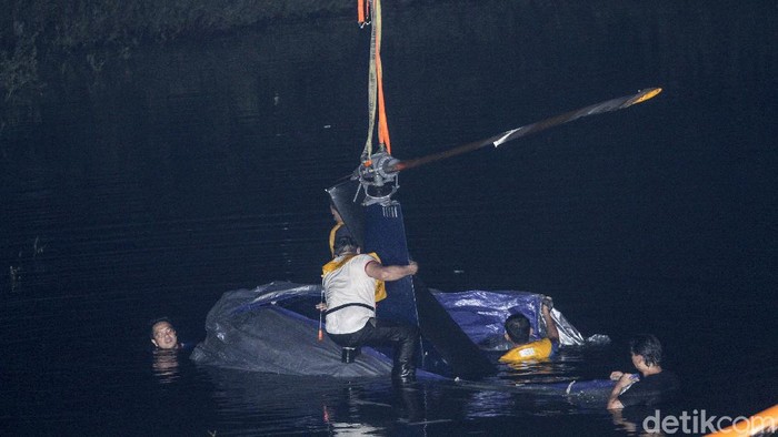 Bangkai Heli Jatuh di Danau Buperta Sudah Dievakuasi Sejumlah warga melihat proses evakuasi pengankatan helikopter latih yang jatuh di Setu Rawa Jemblong, Buperta, Depok, Jawa Barat, Sabtu (29/5/2021) dini hari. Kecelakaan helikopter latih jenis Robinson R44 yang terjatuh pada Jumat (28/5) pukul 09.15 WIB tersebut tidak menyebabkan korban jiwa. ANTARA FOTO/Asprilla Dwi Adha/hp.