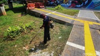 Saat ini tampak beberapa pekerja sedang memotong rumput sekitar JPO Tapal Kuda Tanjung Barat.