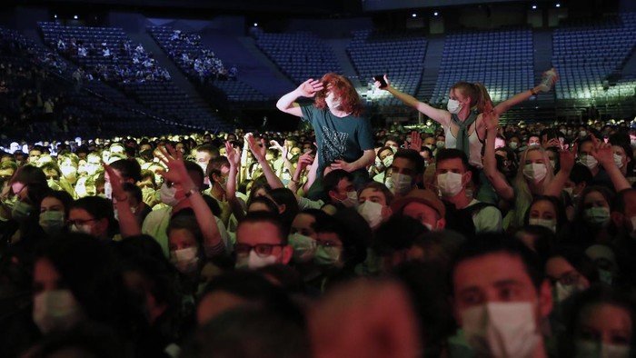 Thousands of people, masked and tested for the virus, pack inside a Paris concert hall as part of a public health experiment to prepare the country to host big events again, in Paris, Saturday, May 29, 2021. The concert in the AccorHotels Arena in eastern Paris features 1980s French rock band Indochine and DJ Etienne de Crecy. (AP Photo/Francois Mori)