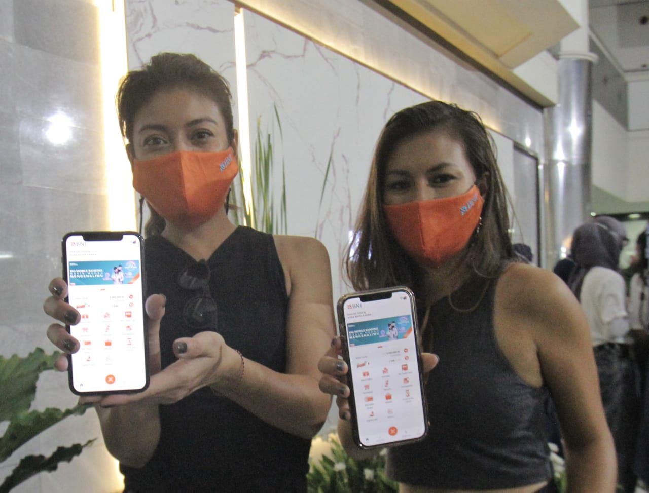 Brand Ambassador BNI Mobile Banking Marianne Rumantir (kanan) dan Sigi Wimala (kiri) menunjukkan aplikasi BNI Mobile Banking