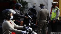 Tiba-tiba, melintas pengendara motor yang tidak mengenakan masker. Petugas pun langsung menyetop kendaraannya.