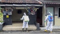 Petugas menyemprot pos ronda tempat berkumpul warga.