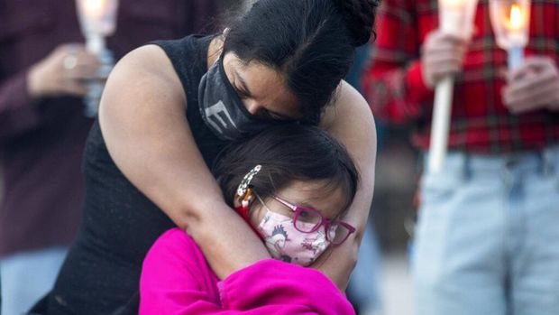 Candles are lit during a vigil in Toronto on Sunday May 30, 2021, for the 215 Indigenous children, whose remains were uncovered on the grounds of a former residential school near Kamloops, British Columbia. The discovery of a mass grave was announced late on Thursday by the Tk'emlups te Secwépemc people after the site was examined by a team using ground-penetrating radar. (Chris Young/The Canadian Press via AP)
