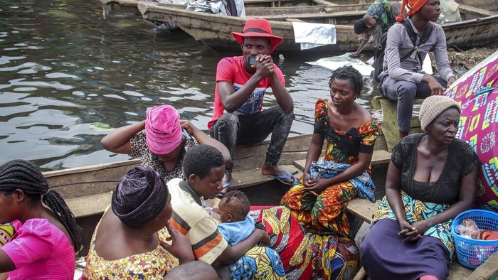 Aksi Warga Kongo Menjauh dari Bencana Residents board boats to flee across Lake Kivu in the direction of South Kivu province, at the port of Kituku in Goma, in eastern Congo Friday, May 28, 2021. Tens of thousands of people are fleeing the city of Goma in eastern Congo fearing another volcanic eruption by Mount Nyiragongo, which spewed lava near the city last week. (AP Photo/Justin Kabumba)