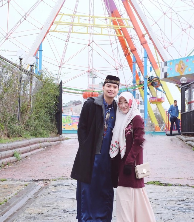 Tak cuma lewat warna, potongan busana juga disenadakan. Saat berlibur, mereka sama-sama menggunakan coat panjang. (Foto: Instagram)