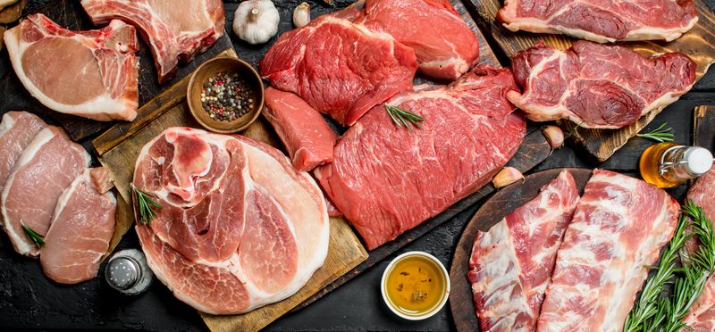 Daging Raw meat. Different kinds of pork and beef meat. On a black rustic background.