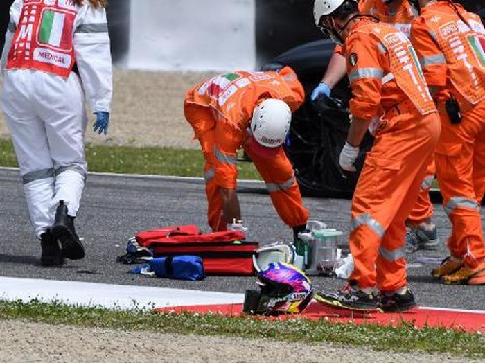 Medical officers clear the track as they evacuate Swiss Moto3 rider Jason Dupasquier in an helicopter after a crash during a qualifying session ahead the Italian Moto GP Grand Prix at the Mugello race track in Scarperia e San Piero on May 29, 2021. - Swiss Moto3 rider Jason Dupasquier was being taken to hospital after a three-bike crash that halted qualifying for the Italian motorcycling Grand Prix at Mugello on May 29, 2021. Organisers said the stricken teenager was being taken to hospital in Florence to undergo tests. Japanese rider Ayumu Sasaki and Spaniard Jeremy Alcoba were the others involved in the accident which delayed the MotoGP fourth practice with organisers reporting both were fine. (Photo by Tiziana FABI / AFP)