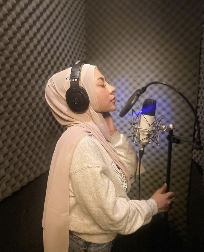 Pelantun lagu Bahagia Telah Datang itu aktif di Instagram dan kerap mengunggah foto OOTD hingga aktivitasnya sehari-hari. Dalam kesehariannya, Liza suka memakai hijab pashmina. Seperti dalam foto ini ia memakai hijab pashmina saat berada di studio rekaman. Foto: Dok. Instagram @lzadtya.