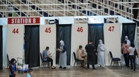 Sejumlah petugas kesehatan memberi arahan kepada warga yang hendak melaksanakan vaksinasi COVID-19 di pusat vaksinasi yang berada di kawasan Kuala Lumpur, Malaysia, Senin (31/5/2021).  