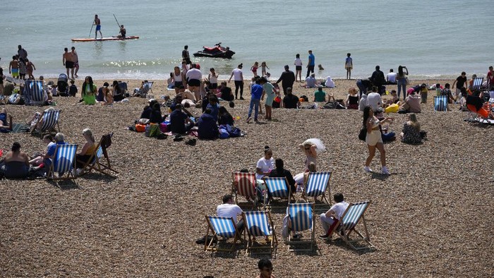 People gather during a hot day on Brighton Beach, in Brighton, on England's south coast, Sunday, May 30, 2021. The bank holiday weekend and relaxation of England's coronavirus restrictions has enabled many people to visit beaches, as warm weather spreads across the UK after what has been a very rainy May. (AP Photo/Matt Dunham)