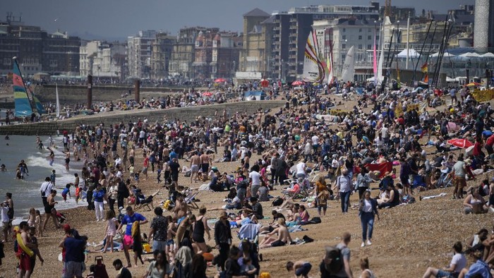 Pandemi Belum Usai, Pantai di Inggris Padat Wisatawan People gather during a hot day on Brighton Beach, in Brighton, on England's south coast, Sunday, May 30, 2021. The bank holiday weekend and relaxation of England's coronavirus restrictions has enabled many people to visit beaches, as warm weather spreads across the UK after what has been a very rainy May. (AP Photo/Matt Dunham)