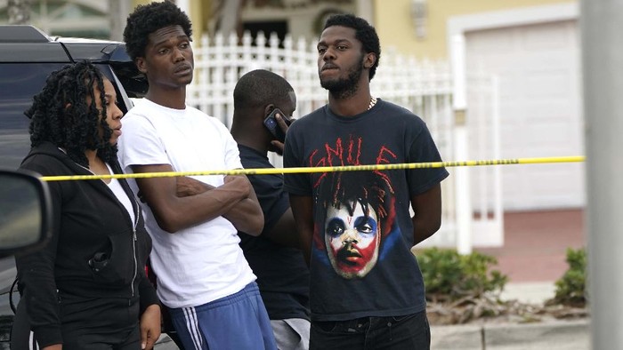 People wait for information outside the scene of a shooting at a banquet hall near Hialeah, Fla., Sunday, May 30, 2021. Two people died and an estimated 20 to 25 people were injured in a shooting outside a banquet hall in South Florida, police said. The gunfire erupted early Sunday at the El Mula Banquet Hall in northwest Miami-Dade County, near Hialeah, police told news outlets. (AP Photo/Lynne Sladky)