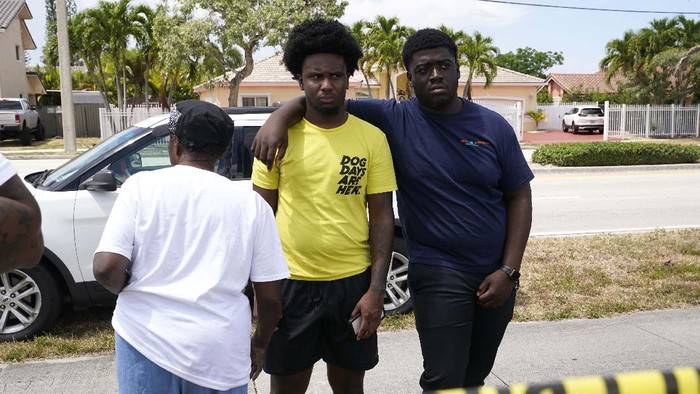 People wait for information outside the scene of a shooting at a banquet hall near Hialeah, Fla., Sunday, May 30, 2021. Two people died and an estimated 20 to 25 people were injured in a shooting outside a banquet hall in South Florida, police said. The gunfire erupted early Sunday at the El Mula Banquet Hall in northwest Miami-Dade County, near Hialeah, police told news outlets. (AP Photo/Lynne Sladky)