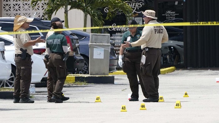 People wait for information outside the scene of a shooting at a banquet hall near Hialeah, Fla., Sunday, May 30, 2021. Two people died and an estimated 20 to 25 people were injured in a shooting outside a banquet hall in South Florida, police said. The gunfire erupted early Sunday at the El Mula Banquet Hall in northwest Miami-Dade County, near Hialeah, police told news outlets. (AP Photo/Lynne Sladky)