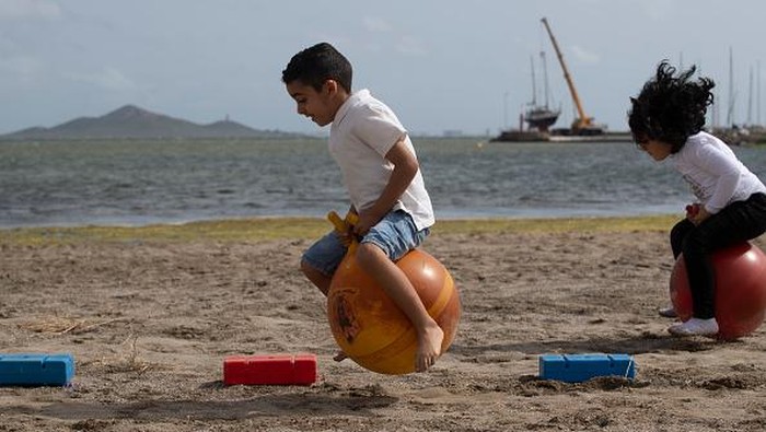Serunya Siswa Brasil Sekolah Tatap Muka di Pantai CARTAGENA, SPAIN - MAY 26: Students from Colegio Felix Rodriguez de la Fuente attend their graduation ceremony on Los Nietos beach in the Mar Menor, where they have been developing their classes during the pandemic, on May 26, 2021 in Cartagena, Spain. The open-air learning is part of the Felix Rodriguez de la Fuente school's program of creating healthier environments for school children during the COVID-19 pandemic. (Photo by Alfonso Duran/Getty Images)