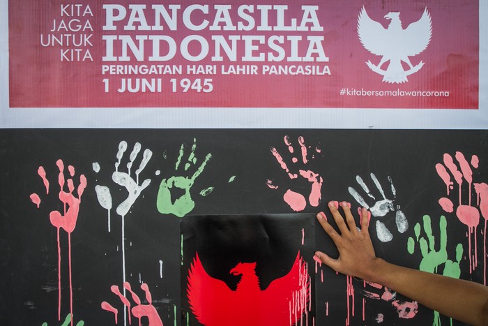 Mahasiswa Desain Komunikasi Visual (DKV) Fakultas Seni Rupa dan Desain (FSRD) Institut Seni Indonesia (ISI) Solo mengecap tangan dengan cat warna saat kegiatan Aksi Seni Rupa Menyambut Hari Lahir Pancasila di Ngarsapura, Solo, Jawa Tengah, Senin (31/5/2021). Aksi tersebut untuk menumbuhkan semangat jiwa nasionalisme dan cinta tanah air melalui nilai-nilai luhur Pancasila kepada generasi muda. ANTARA FOTO/Mohammad Ayudha/rwa.