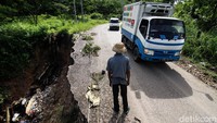 Pengendara melewati jalan yang sebagian longsor di lintas Kertas Kraf Aceh (KKA) ke Bener Meriah di kawasan KM 35 Jabal Antara, Aceh Utara, Aceh, Selasa (1/6/2021). 