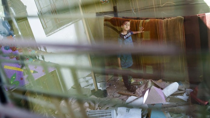 Potret Pilu Anak-anak Gaza Ratapi Kamar Tidurnya Hancur Mahmoud Al-Masri, 14, stands for a portrait in his bedroom that was damaged when an airstrike destroyed the neighboring building prior to a cease-fire that halted an 11-day war between Gaza's Hamas rulers and Israel, Wednesday, May 26, 2021, in Beit Hanoun, Gaza Strip. (AP Photo/John Minchillo)
