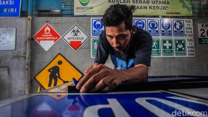Proyek Tol Bikin Pembuat Marka Jalan Banjir Order Perajin menyelesaikan pembuatan daun rambu lalu lintas untuk marka jalan termasuk jalan tol di Jl Ciater Baru, Tangerang Selatan, Banten, Selasa (1/6/2021). Dibukanya sejumlah tol baru berdampak pada banjirnya pesanan sarana perlengkapan rambu lalu lintas yang dijual dari harga Rp1,2 juta hingga belasan juta rupiah tergantung besar ukuran rambu.