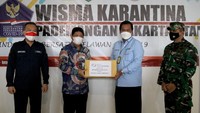 Direktur Kepesertaan BPJAMSOSTEK Zainudin, menyerahkan secara simbolis bantuan kepada Kasubdit Karantina Kesehatan Dirjen Pencegahan dan Pengendalian Kemenkes dr. Benget Saragih di Wisma Atlet Pademangan, Jakarta, Rabu (2/6/2021). 