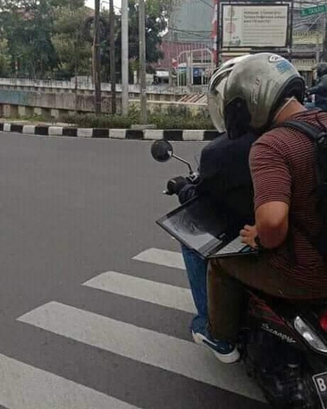 Kalau yang namanya sudah deadline, kerjainnya dimanapun jadi deh. Kayak yang satu ini nih, lagi di motor pun tetap buka laptop. Foto: Instagram/@shitvoss