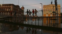 Akibat banjir yang tak kunjung surut, warga membuat jembatan kayu darurat untuk lalu lintas pejalan kaki.  