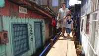 Tampak jalan darurat dari papan kayu berdiri di antara pemukiman warga.  
