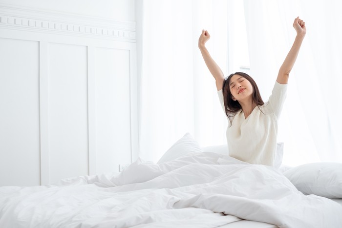 Ilustrasi Bangun Pagi Asian woman wake up in the morning, sitting on white bed and stretching, feeling happy and fresh