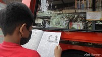 Seorang anak tengah membaca buku.