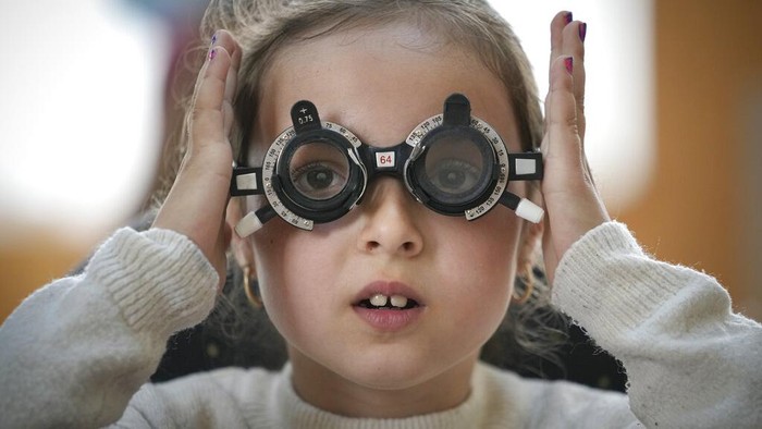 A boy undergoes an eyesight examination performed by volunteer ophthalmologists, in Nucsoara, Romania, Saturday, May 29, 2021. Dozens of disadvantaged young Romanian children got a chance to get their eyesight examined for the first time in their lives during an event arranged by humanitarian organization Casa Buna, or Good House, which has played a prominent role in supporting the local children's lives throughout the pandemic. (AP Photo/Vadim Ghirda)