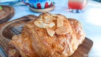Almond croissant (30 ribu) cocok buat sarapan. Tekstur bagian luarnya renyah dan dalamnya lembut. Selain terdapat di topping, irisan almond juga dijadikan isian croissant. Rp Foto: detikFood/Yenny Mustika Sari
