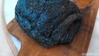 Black Chocolatine (Rp 24 ribu) punya rasa yang nikmat. Berupa puff pastry berwarna hitam yang berasal dari charcoal, lalu di dalamnya berisikan selai cokelat jenis couverture. Foto: detikFood/Yenny Mustika Sari